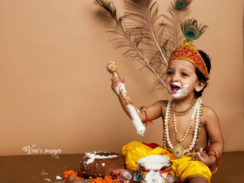 Baby boy eating butter in krishna outfit, photography by Vinus Images in Dellhi